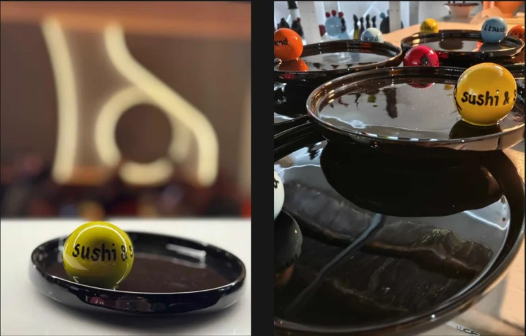 Yellow sushi ball resting on a black glossy plate, with a blurred restaurant interior in the background (left panel).